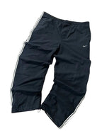 modadeclase Vintage Nike Trackpants in Schwarz mit weißen Seitenstreifen, Swoosh-Logo und verstellbaren Saumkordeln.